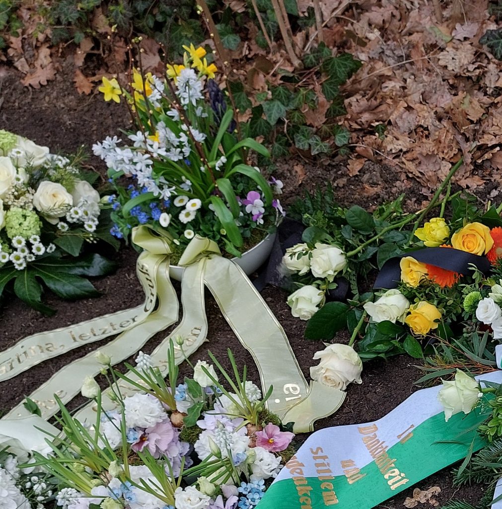 Blumengestecke auf einem Friedhof (Bild: Amelie Rehm)