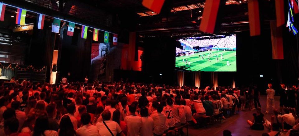 In der Halle 45 verfolgen Fußballfans das WM-Spiel Deutschland gegen Paraguay.