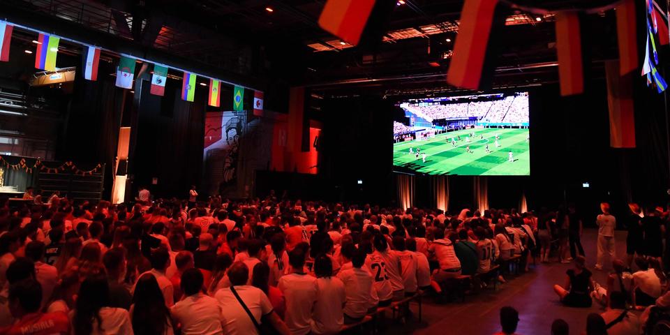 In der Halle 45 verfolgen Fußballfans das WM-Spiel Deutschland gegen Paraguay.